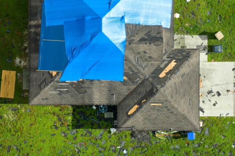 wind damage on roof covered with tarp